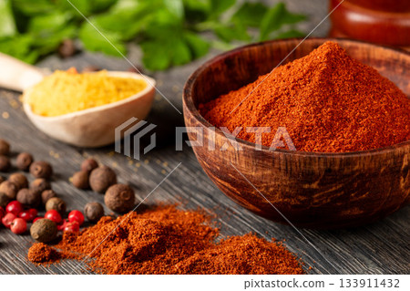Detailed close-up of red ground pepper in a traditional wooden bowl 133911432
