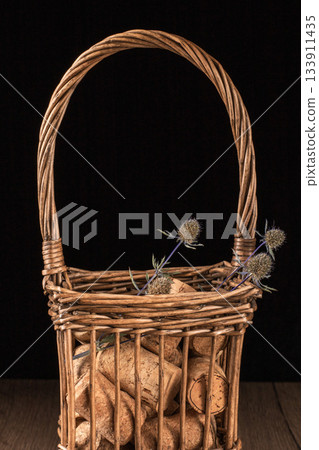 A vintage inspired basket overflowing with wine corks on a rustic tabletop 133911435