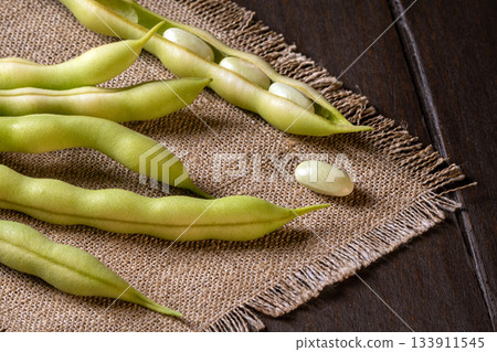 Close-up of asparagus beans on a rustic burlap napkin for culinary presentation Close-up of asparagus beans on a rustic burlap napkin for culinary presentation 133911545