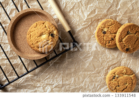 Delicious oatmeal cookies with raisins on a rustic paper background, flat lay 133911548