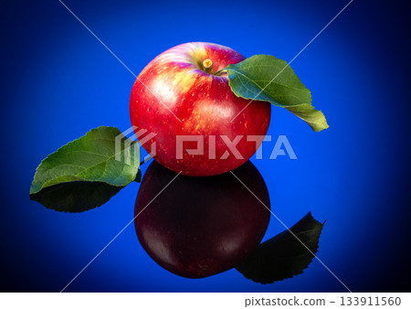 Stunning art photo of a ripe red apple on a beautiful blue gradient background 133911560