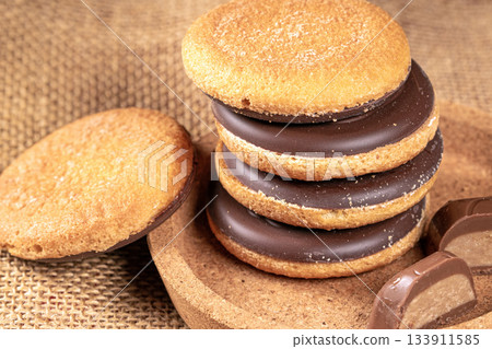 Delicious stack of chocolate cookies piled on a rustic burlap napkin 133911585