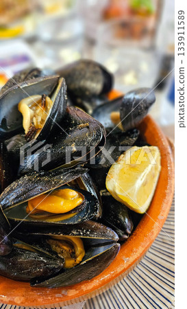 Close-up shot of a plate of fresh mussels served on a restaurant table Close-up shot of a plate of fresh mussels served on a restaurant table 133911589