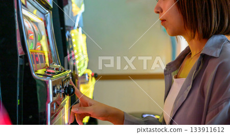 日本女性在渡輪上的遊戲中心玩老虎機 日本女性在渡輪上的遊戲中心玩老虎機 133911612