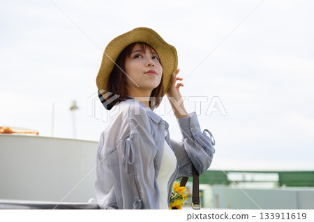 Portrait of a woman in a straw hat immersed in travel on a summer ferry Portrait of a woman in a straw hat immersed in travel on a summer ferry 133911619