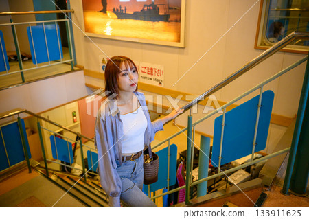 Portrait of a young woman climbing stairs on a ferry Portrait of a young woman climbing stairs on a ferry 133911625