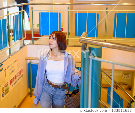 Portrait of a young woman standing on the stairs inside a ferry 133911632