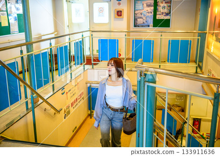 A young man descending the stairs on a ferry bound for Oki Island A young man descending the stairs on a ferry bound for Oki Island 133911636