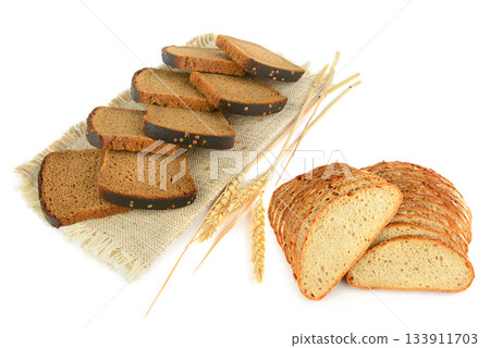 Variety of Sliced Bread and Wheat Ears on Burlap Isolated on White Variety of Sliced Bread and Wheat Ears on Burlap Isolated on White 133911703