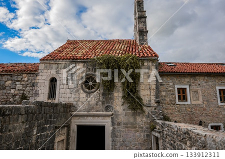 Wide-angle view of Santa Maria in Punta, one of the oldest churches in Budva, Montenegro, situated in the historic Old Town. Shows the full structure, surrounding narrow streets, and Mediterranean Wide-angle view of Santa Maria in Punta, one of the oldest churches in Budva, Montenegro, situated in the historic Old Town. Shows the full structure, surrounding narrow streets, and Mediterranean 133912311