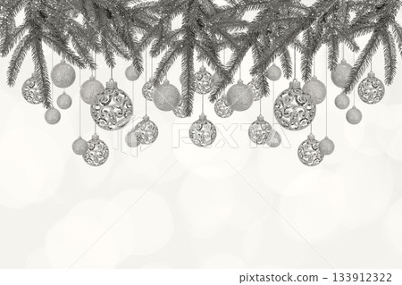 Demonstrating the colors of 2026 - Cloud Dancer. Christmas tree baubles on background with branches of Christmas trees and lights. Design with copy space for greeting card, text, advertising 133912322