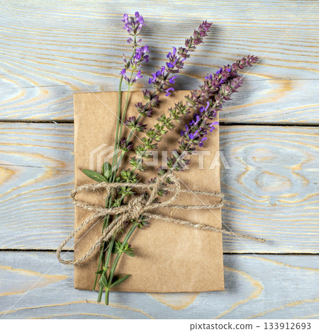 Mockup of a paper bag on a wooden table accompanied by lavender flowers 133912693