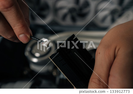 Closeup hands of technician male installing wi-fi module into desktop computer, demonstrating process of upgrading or repairing computer hardware at workshop. Concept of modern technology. Closeup hands of technician male installing wi-fi module into desktop computer, demonstrating process of upgrading or repairing computer hardware at workshop. Concept of modern technology. 133912773