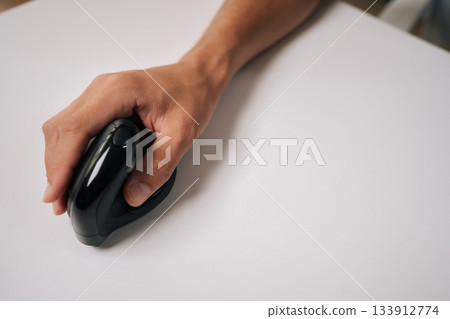 Closeup cropped shot of male hand holding vertical ergonomic mouse on white background, highlighting design and promoting comfortable computer use for work or gaming, copy space. Closeup cropped shot of male hand holding vertical ergonomic mouse on white background, highlighting design and promoting comfortable computer use for work or gaming, copy space. 133912774