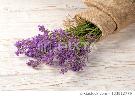 Lush bouquet of lavender flowers displayed attractively on rustic wooden furniture 133912779