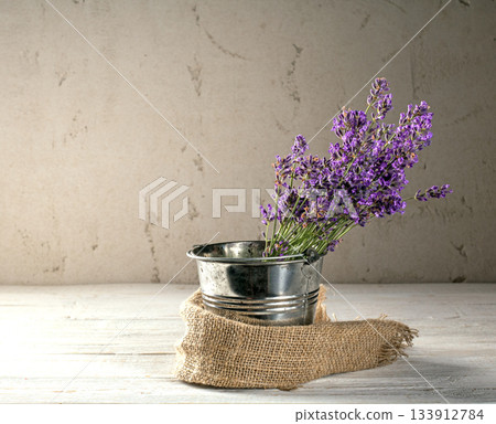Charming lavender bouquet in a small metal bucket on a rustic plaster background 133912784