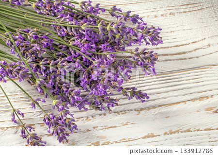 Charming lavender bouquet artfully arranged on a rustic wooden surface for relaxation 133912786