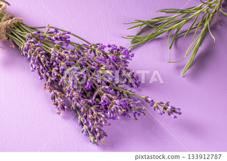 Vibrant lavender bouquet with green stems against a soft lavender background 133912787