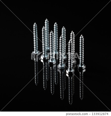 Stunning reflection of metal bolts on a black mirrored background 133912874