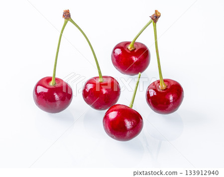 Vibrant ripe cherries placed on a white background captured in side view perspective Vibrant ripe cherries placed on a white background captured in side view perspective 133912940