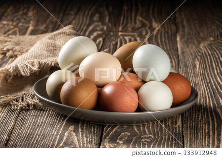 Charming display of eco-conscious chicken eggs on rustic wooden farm table Charming display of eco-conscious chicken eggs on rustic wooden farm table 133912948