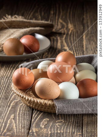 Sustainable farm-raised chicken eggs beautifully arranged on wooden table Sustainable farm-raised chicken eggs beautifully arranged on wooden table 133912949