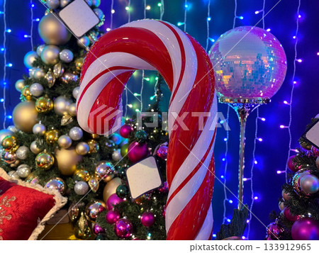 Giant Christmas red and white candy cane decor in a festive hall. Christmas celebration, holiday decoration, sweet-themed winter interior and joyful seasonal atmosphere 133912965