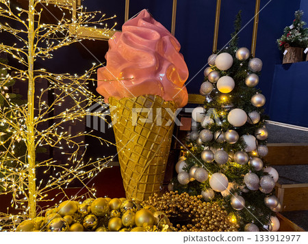 Christmas Giant ice cream sculpture between festive trees and golden lights in holiday decor. Playful fantasy installation, Christmas sweetness, winter wonder mood and joyful celebration vibe. Christmas Giant ice cream sculpture between festive trees and golden lights in holiday decor. Playful fantasy installation, Christmas sweetness, winter wonder mood and joyful celebration vibe. 133912977