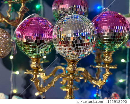 Christmas Mirror disco ball ornaments on antique gold holder under festive lights. Party glamour, retro celebration spirit, holiday sparkle, Holidays joy and vibrant seasonal energy. 133912990