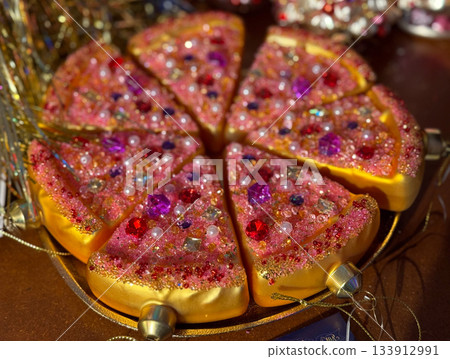 Christmas bauble Glitter pizza slices covered with gems and beads as decorative Christmas piece. Celebration fun, creative holiday styling, whimsical festive accents and joyful seasonal sparkle. 133912991