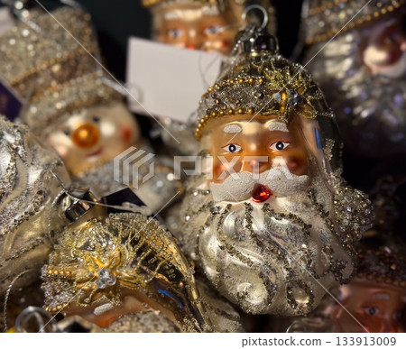 Golden santa ornament in festive holiday display. Joyful christmas celebration through sparkling craft, seasonal tradition, winter mood, warm nostalgia, family spirit and magical decorative charm. Golden santa ornament in festive holiday display. Joyful christmas celebration through sparkling craft, seasonal tradition, winter mood, warm nostalgia, family spirit and magical decorative charm. 133913009
