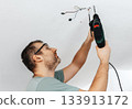 Man drilling a hole in the 133913172
