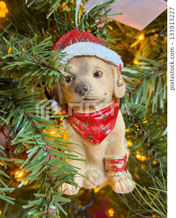 Holiday puppy ornament on a festive Christmas tree. Joyful warmth and seasonal charm in a glowing celebration of winter magic and traditional decor creating emotional connection and cozy holiday 133913227
