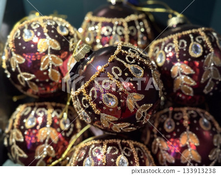 Ornate burgundy Christmas baubles with gold detail. Holiday luxury, seasonal artistry and elegant decoration. 133913238