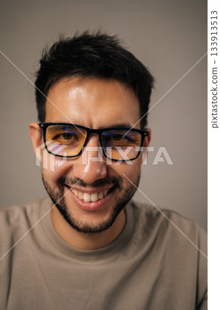Headshot portrait of cheerful young man with beard and glasses smiling broadly looking at camera, expressing joy, success, confidence, reflecting positive attitude, wellbeing on isolated background. Headshot portrait of cheerful young man with beard and glasses smiling broadly looking at camera, expressing joy, success, confidence, reflecting positive attitude, wellbeing on isolated background. 133913513