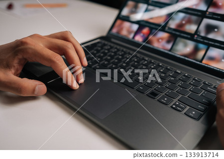 Cropped shot of male hand navigating touchpad on laptop keyboard during online meeting, emphasizing essence of remote work and modern digital communication. Concept of remote workplace. Cropped shot of male hand navigating touchpad on laptop keyboard during online meeting, emphasizing essence of remote work and modern digital communication. Concept of remote workplace. 133913714