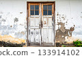 Weathered Double Doors in Old Building Facade 133914102
