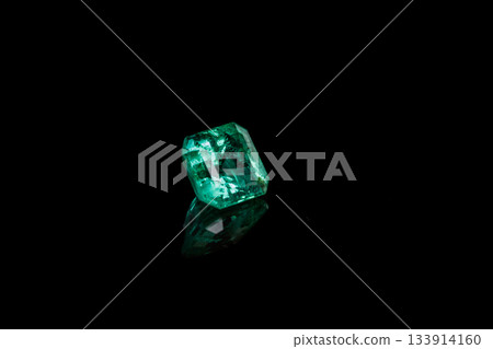Macro mineral Emerald gemstone faceted on black background Macro mineral Emerald gemstone faceted on black background 133914160