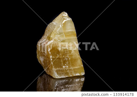 Macro mineral stone yellow Calcite on a black background 133914178