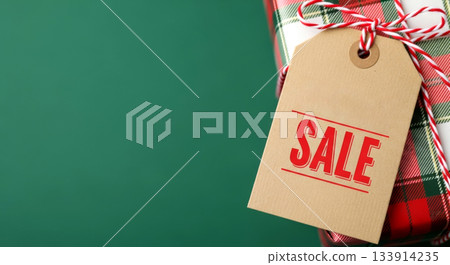 Plaid-wrapped gift with SALE tag. Christmas discounts, seasonal offers, and holiday shopping. 133914235