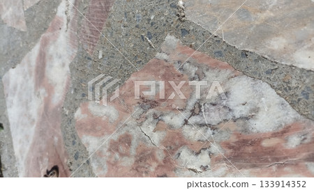 A close-up of a terrazzo surface, featuring a mix of marble chips and concrete. Perfect for design projects that highlight durable and stylish materials with unique textures. 133914352