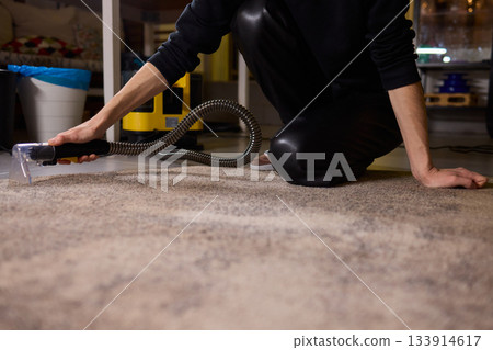 Maintenance technician performs thorough carpet extraction, Professional technician utilizes portable tool to deeply clean and rejuvenate stained commercial carpets Maintenance technician performs thorough carpet extraction, Professional technician utilizes portable tool to deeply clean and rejuvenate stained commercial carpets 133914617