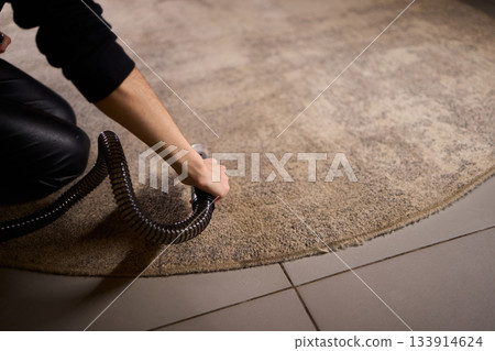 Maintenance technician performs thorough carpet extraction, Professional technician utilizes portable tool to deeply clean and rejuvenate stained commercial carpets Maintenance technician performs thorough carpet extraction, Professional technician utilizes portable tool to deeply clean and rejuvenate stained commercial carpets 133914624