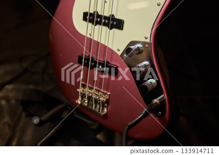 Intimate musical scene, Closeup of bass with ambiance, Detailed view of guitar and musician atmosphere, Focused image of bass guitar and drummer in dim ambiance 133914711