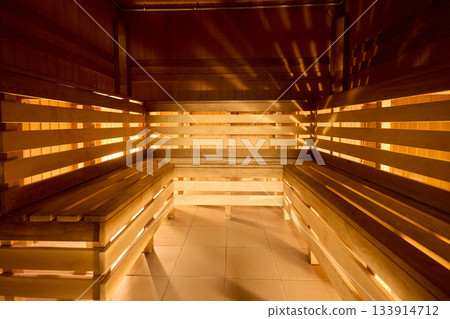 Relaxing wooden sauna ambiance, Serene sauna environment with warm lighting and seating, Inviting sauna space featuring soft glow and layered benches for relaxation Relaxing wooden sauna ambiance, Serene sauna environment with warm lighting and seating, Inviting sauna space featuring soft glow and layered benches for relaxation 133914712