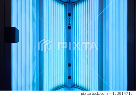 Modern therapeutic tanning setup, Elegant spa environment with ultraviolet illumination, Sophisticated cosmetic treatment station with illuminated UV lamps and sleek equipment Modern therapeutic tanning setup, Elegant spa environment with ultraviolet illumination, Sophisticated cosmetic treatment station with illuminated UV lamps and sleek equipment 133914713