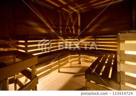 Relaxing wooden sauna ambiance, Serene sauna environment with warm lighting and seating, Inviting sauna space featuring soft glow and layered benches for relaxation Relaxing wooden sauna ambiance, Serene sauna environment with warm lighting and seating, Inviting sauna space featuring soft glow and layered benches for relaxation 133914724