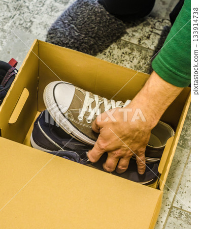 Man Packing Sneakers Into Cardboard Storage Box Man Packing Sneakers Into Cardboard Storage Box 133914738