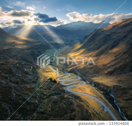 Aerial view of winding mountain road in the Swiss Alps at sunset 133914808