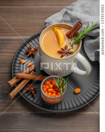 Sea buckthorn herbal tea in a cup on a black plate on a wooden background Sea buckthorn herbal tea in a cup on a black plate on a wooden background 133914862